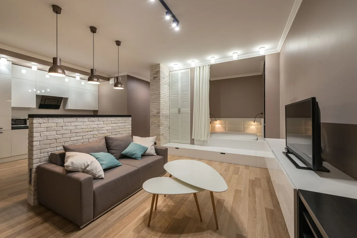 A furnished living area with a sofa, coffee table and pendant lights