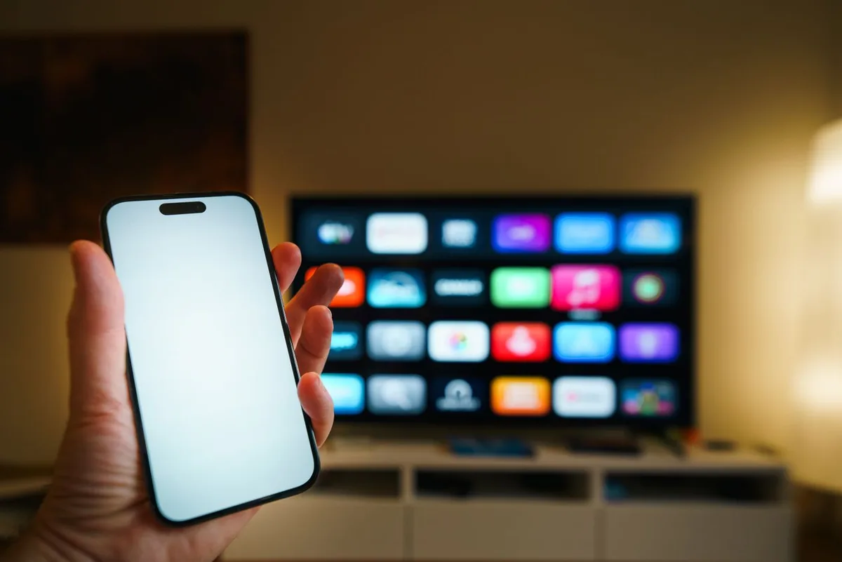 A smartphone in front of a television in a living room